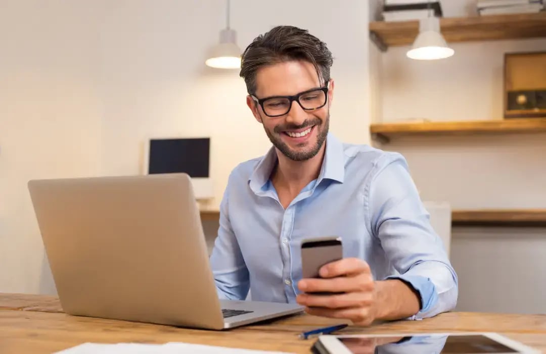 Online positionering_blij_werknemer_bureau_laptop_meeting